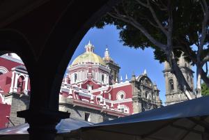 a large red and white building with a clock tower at Departamento #8 frente al Zócalo de Puebla en casona del siglo XVI in Puebla