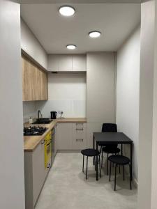 una cucina con tavolo e alcune sedie di Pokoje weekendowe w centrum Lublina a Lublino