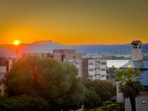 a sunset over a city with a clock tower at bbolbia - rooms and breakfast in Olbia