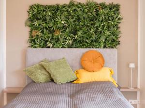 a large green hedge behind a bed with pillows at Schön hier in Wehr