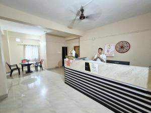 a man standing at the counter of a restaurant at Serene Dawn Homestay in Guwahati