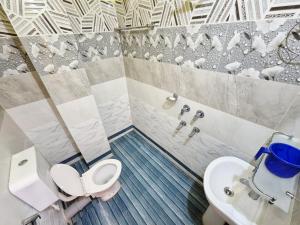 a bathroom with a toilet and a sink at Serene Dawn Homestay in Guwahati