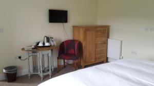 a bedroom with a desk and a bed and a bed and a desk with at Kilsham Farm in Petworth
