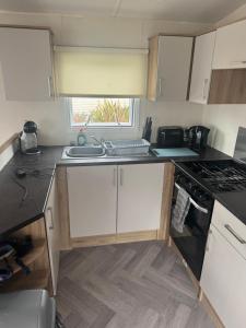 a small kitchen with a sink and a stove at Dawbers Retreat in Selsey