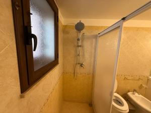 a bathroom with a shower and a toilet and a window at Villa Sole in Petrosino +17 photos