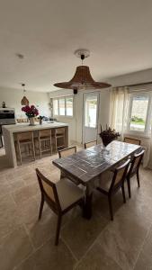 een keuken met een houten tafel en stoelen en een tafel en een tafel bij Kaz Bohèm in Ambleteuse