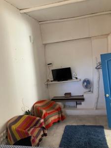 a living room with a tv on the wall at Santorini house y Santorini house 2 in San Pedro de Atacama