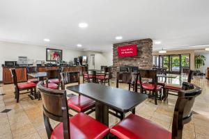 Un restaurante con mesas y sillas y un bar. en Red Roof PLUS Henderson, en Henderson