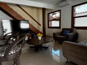 パラチにあるPousada dos Navegantesのリビングルーム(テレビ、テーブル、椅子付)