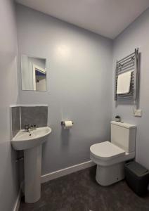 a white bathroom with a toilet and a sink at The Railway Inn in Kyle of Lochalsh
