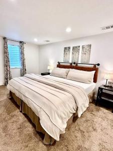a large white bed in a bedroom with two windows at Mid-mod Home 3 Baths 2 Living Rms Yard in Centennial