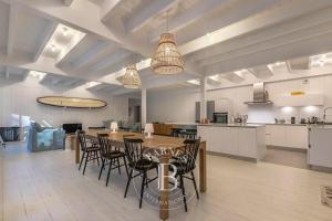 a large room with a table and chairs and a kitchen at La Cabane du Cap Ferret in Lège-Cap-Ferret