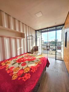 a bedroom with a bed with a red blanket at Loft pertinho do Aeroporto de Navegantes! in Navegantes