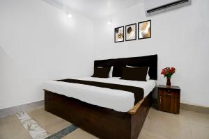 Un dormitorio con una cama y una mesa con flores. en Super Hotel O Gaya Railway Junction Formerly Family Guest House, en Gaya