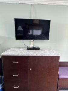a tv on top of a dresser in a room at Budget Inn Orange in Orange