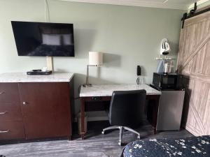 a room with a desk with a computer and a chair at Budget Inn Orange in Orange