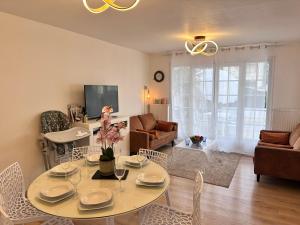 a living room with a table and chairs and a couch at RELAX HOME Maison et studio ensemble in Deauville