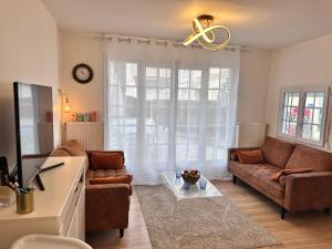 a living room with a couch and a table at RELAX HOME Maison et studio ensemble in Deauville