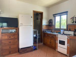 a kitchen with a white refrigerator and a stove at Casitas Las Palmas - Brisa Marina in Punta Mita