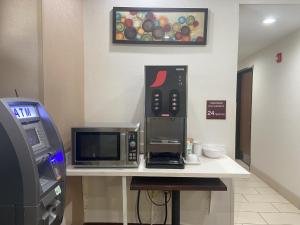 ピッツバーグにあるRed Roof Inn Pittsburgh - McKnight Rdのカウンターの上には電子レンジとポップコーンマシンがあり、公衆電話もある