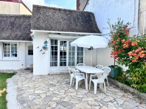 a table and chairs with an umbrella on a patio at RELAX HOME Maison et studio ensemble in Deauville