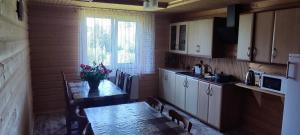 a kitchen with a table with a vase of flowers on it at Saduba Pushkarivchyk in Yablunytsya