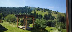 a wooden gazebo in the middle of a field at Saduba Pushkarivchyk in Yablunytsya