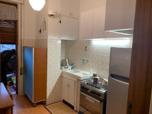 a kitchen with a white refrigerator and a sink at Appartamento Mare Monti in Carrara