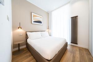 une chambre avec un lit blanc et une fenêtre dans l'établissement Raffaello Moscova Golden House, à Milan