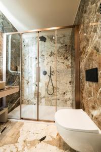 La salle de bains est pourvue d'une douche, de toilettes et d'une baignoire. dans l'établissement Raffaello Moscova Golden House, à Milan