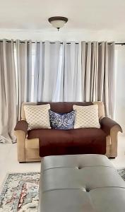un sofá en una sala de estar con cortinas blancas en Sunset Serenity 2BR Oceanview Beach & Pool Access, en Negril