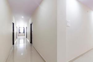a hallway of a building with white walls and white floors at Hotel O Shannu Residency in Secunderabad