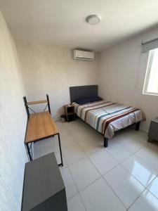 a bedroom with a bed and a table in it at Tulum confort in Tulum