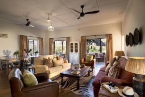 a living room with couches and a dining room at Baobab Hill House in Makuleke Contract Park