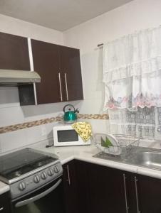 a kitchen with a stove and a microwave at Cuarto amueblado in Guadalajara