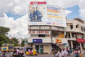 a sign on the side of a building on a busy street at Hotel O Shannu Residency in Secunderabad
