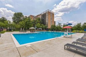 a large swimming pool with chairs and a building at Boutique Suite-Sleeps 7-Free Parking-Balcony Views in Arlington