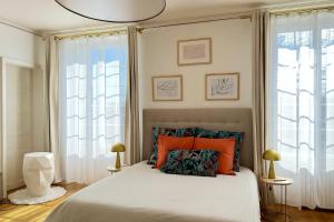 ランスにあるHôtel Particulier - 5 minutes de Reimsのベッドルーム1室(オレンジ色の枕が付いたベッド1台付)