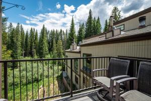 - Balcón con silla y vistas al bosque en 500 Vasquez Road #5 3BR Townhome in Downtown Winter Park with Deck, en Winter Park