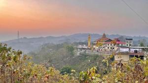 a view of a building on a hill at sunset at Cloudy Inn Resort in Bāndarban