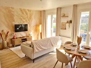 a living room with a couch and a table at La maison du canal - garage, balcon et jardin in Tonnerre