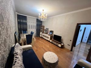 a living room with a couch and a table and a chandelier at Sumqayıt Kristal in Sumqayıt