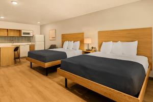 a hotel room with two beds and a kitchen at LivAway Suites Salt Lake City- Draper in Draper