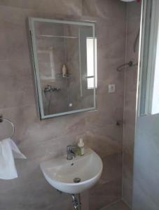 a bathroom with a sink and a shower with a mirror at Apartman Silvija Čiovo in Slatine +20 photos