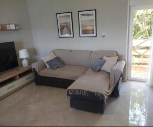 a living room with a couch and a tv at Apartman Silvija Čiovo in Slatine