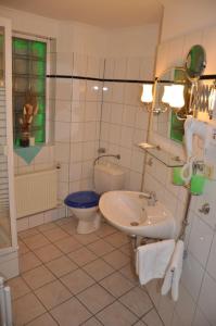 a bathroom with a sink and a toilet at Hotel-Café Kampe in Norderstedt