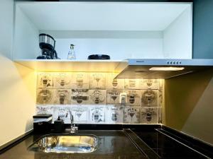 a kitchen with a sink and a wall with cups at Apê para 4 Hóspedes no Brás – A 5min do Metrô in Sao Paulo