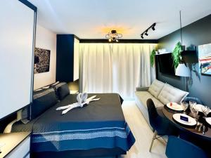 a bedroom with a bed and a table and a couch at Apê para 4 Hóspedes no Brás – A 5min do Metrô in Sao Paulo