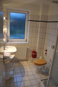 ノルダーシュテットにあるHotel-Café Kampeのバスルーム(トイレ、洗面台付)、窓が備わります。