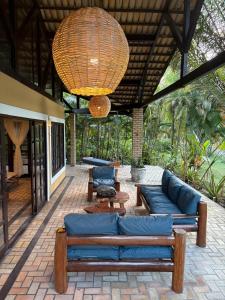 un salon avec un canapé bleu sur un patio dans l'établissement Holiday Villa Praia da Pipa-5 Suites,Areá Gourmet by PipaCharme, à Pipa 65 autres photos